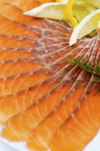 Sliced smoked salmon served with lemon slices