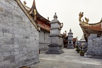 Inner courtyard with grey stone walls in traditional Asian architecture and decorated roofs, The