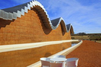 Fragment of the facade is reflected in the pool. Winery - bodega Bodegas Ysios. Journey to the warm