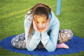Family children's party. Beautiful teenage girl is engaged in yoga on the playground