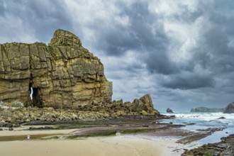Noon on the beach of Playa di Arnia, Spain. Rocky picturesque ocean coast. Cantabria. Windy stormy