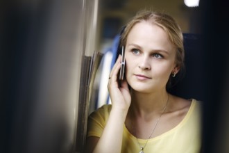 Attractive woman listening to a call on her mobile phone looking into the distance with a