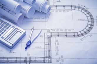 Stack of rolled blueprints calculator compass construction concept