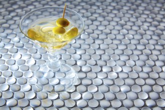 White vermouth cocktail on modern stainless steel circle pattern table