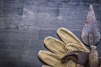 Vintage dusted and rusted tools hammer and spattle on glove