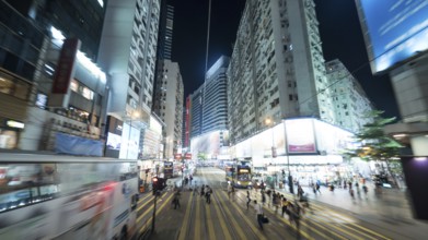 Ride by double-decker tram along the street of night illuminated Hong Kong. View from upper deck