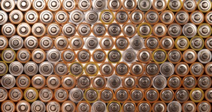 Multiple used AA alkaline batteries are seen arranged in a pile. Closeup front view from the plus