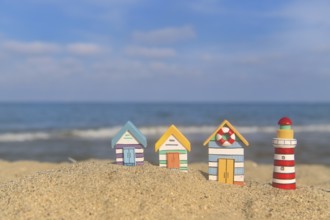 Miniature wooden huts and lighthouse at the beach
