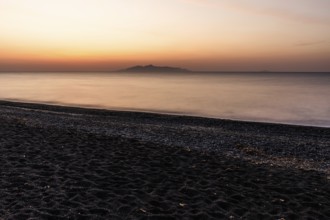 Dawn at sunrise, view from the lava beach near Kamari to the island of Anafi, long exposure, island
