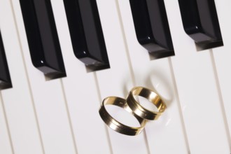 Detail of piano keyboard and wedding rings
