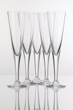 Five champagne glasses on a glass plate