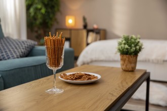 This is a stylish living space that includes pretzel snacks and indoor plants to create a cozy,