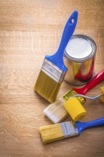 Set of paint brushes roller and can on wooden board