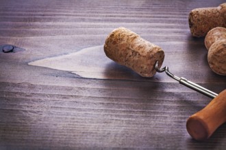 Classic corkscrew twisted in cork of champagne on vintage wooden board alcohol concept