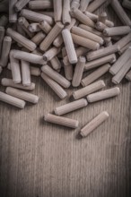 Variety of cylinder wooden dowel pins on wood board construction concept