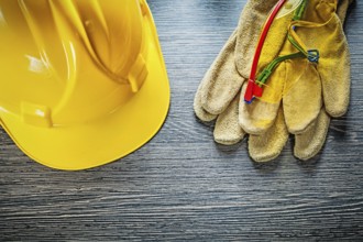 Safety gloves cap goggles on wooden board