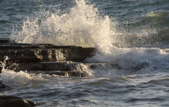 Splashing stormy windy sea waves on a rocky seashore. Storm weather, ocean