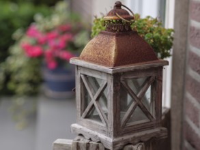 Rustic, rusty lamp on a wooden railing, surrounded by plants, Borken, Münsterland, Germany, Europe