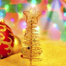 Christmas golden tree with baubles in blur lights background