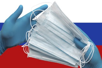 Doctor holding face masks in hands surgical blue gloves on background national flag of Russia.