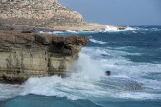 Waves crashing on rocky coast. Windy weather, Powerful sea waves braking on rocks