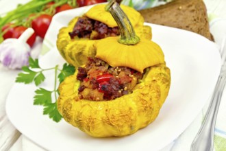Two yellow squash stuffed with meat, tomatoes and peppers in the dish, bread, garlic, parsley and a