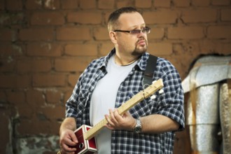 Man playing his three string cigar box guitar