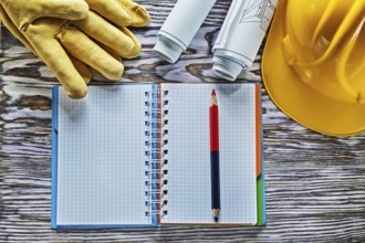 Protective gloves building helmet blueprints notepad pencil