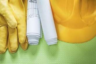 Protective leather gloves building helmet engineering drawings on green background construction