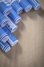Assortment of blue blueprint rolls on wooden board