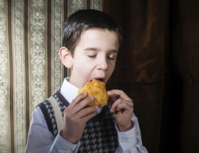 Child who eat donut. Vintage clothes and background
