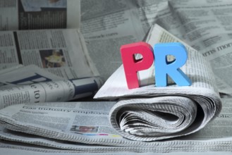 Word PR on newspaper. Wooden letters