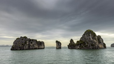 Rocky islands in the calm sea under a grey sky, The landscape and islands of Halong Bay in Vietnam