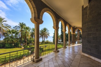 The basilica is surrounded by gallery with columns. Subtle shade of palms. Church Sermon on the