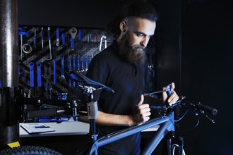 Theme sale and repair of bicycles. Young and stylish with a beard and long hair, a Caucasian man