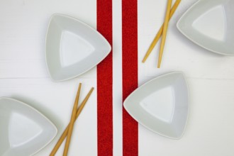 Ceramic bowls and bamboo chopsticks for sushi food with on the white wooden table.Top view. Flat