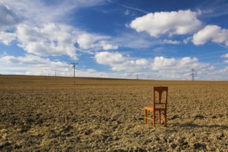 Old wooden chair on the empty field after harvest