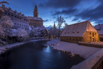 Winter view of Cesky Krumlov, picturesque houses under the castle with snow-covered roofs. Narrow
