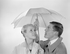 1960s couple. A happy smiling couple is standing under an umbrella. Sweden 1960 Conard ref 4254