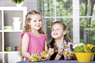 Young girl eating a fruit salad at home. A studio shoot