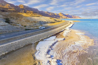 Asphalt highway runs along the seashore. Dead Sea, Israel. Shallowed Dead Sea photographed from a