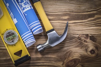 Blue engineering drawings construction level claw hammer on wooden board