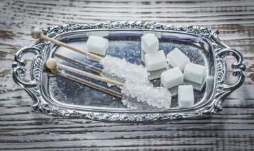 White sugar cubes sticks tray on vintage wooden board