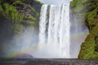 Picturesque rainbow appears in the water mist. The most popular waterfall in Iceland - Skogafoss.