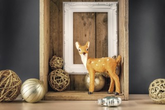 An image of a Christmas decoration wooden box with deer golden balls and a white frame