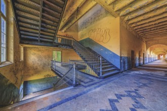 Long, deserted corridor with stairs and graffiti on the walls, Prison H11, Lost Place, Verviers,