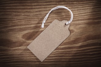 Vintage paper price tag label on old wooden boards close up