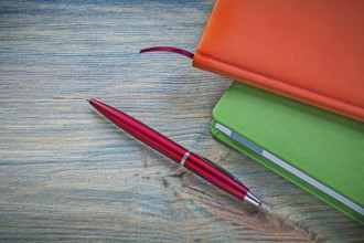 Set of closed notepads ballpoint pen on vintage wooden board office concept