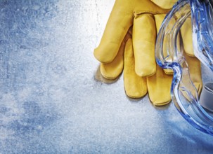 Safety spectacles gloves on scratched metallic background construction concept