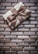 Wrapped present with ribbon on wooden wicker matting holidays concept